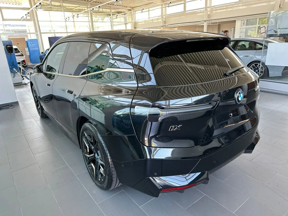 BMW IX M60 2023, vue arrière — Super Car Rental Switzerland, Switzerland. BMW IX M60 in Switzerland La BMW IX M60 2023 s'impose comme une option de location en…